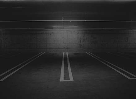 A dark parking lot with two lanes and one lane.