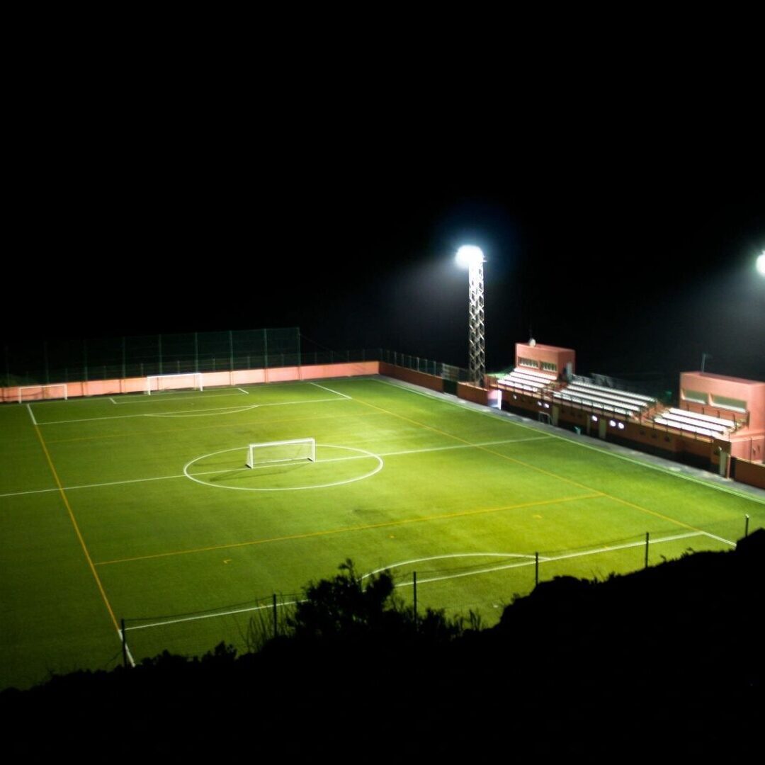 A soccer field with lights on at night.